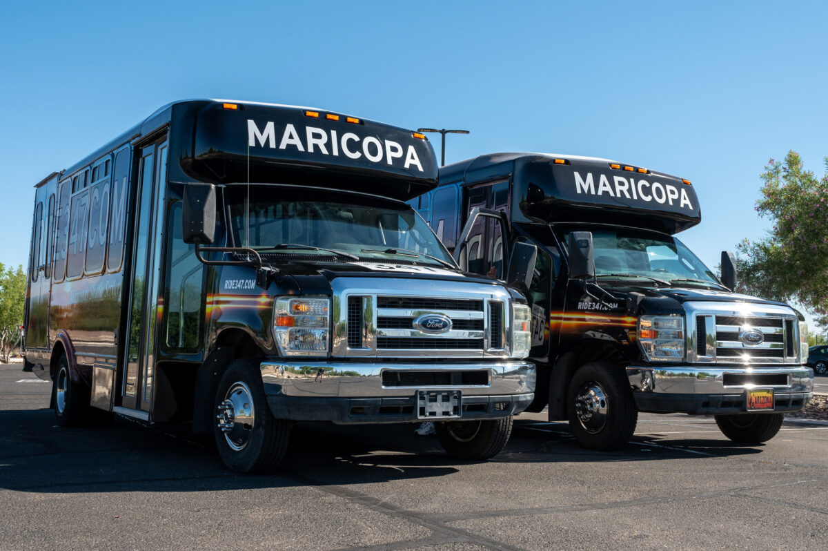 Two black Ride347 airport shuttle buses parked in Maricopa
